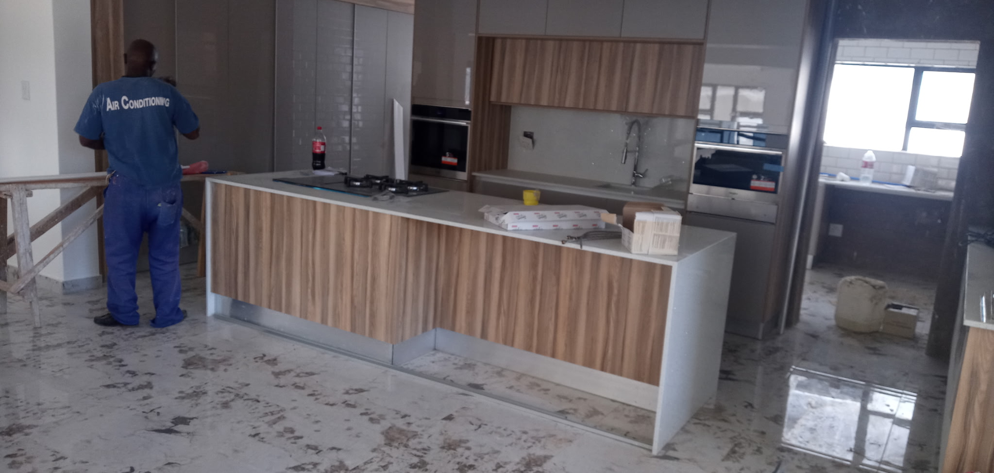 Traditional oak upper cabinets with dark grey lower cabinets and snowy white caesarstone top