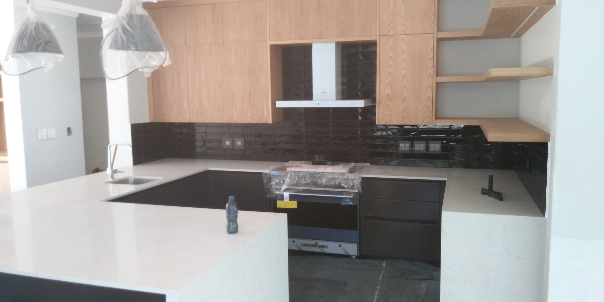 Traditional oak kitchen with dark grey lower cabinets and white caesarstone countertop